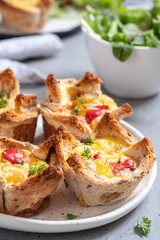 Egg muffins with peppers in a toast cup for breakfast brunch.