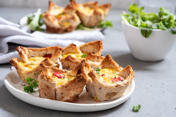 Egg muffins with peppers in a toast cup for breakfast brunch.