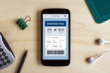 Boarding pass concept on smart phone screen on wooden desk