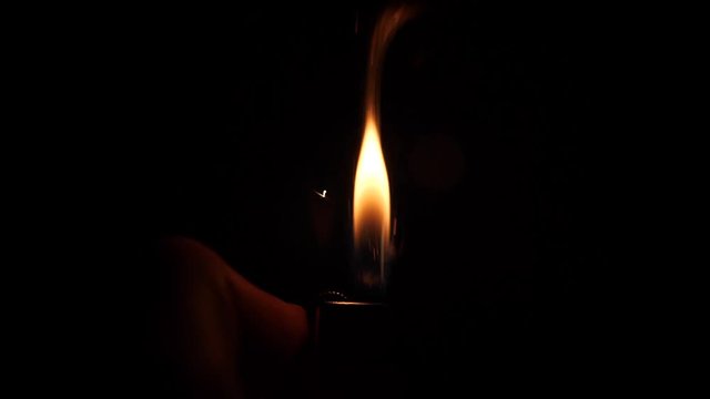 Slow motion shot of turning on a lighter multiple times.