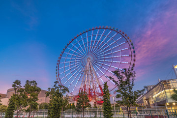 Odaiba illuminated Palette Town Ferris wheel named Daikanransha visible from the central urban area of Tokyo in the summer night sky. Passengers can see the Tokyo Tower.