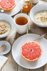 Vegetarian breakfast for two of oatmeal, baked grapefruit and tea. Rustic style.