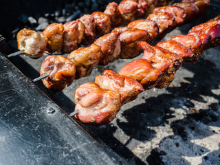 Barbecue skewers meat kebabs with vegetables on flaming grill, Grilled kebab cooking on metal skewers (grill). Roasted meat cooked at barbecue with smoke. Close up BBQ fresh pork meat chop slices.