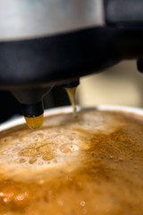 espresso coffee poured into a mug in the coffee machine