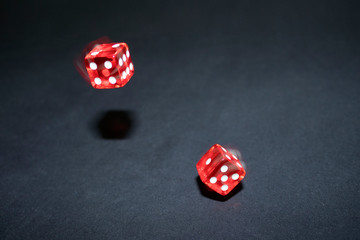 red dice in motion on a black background