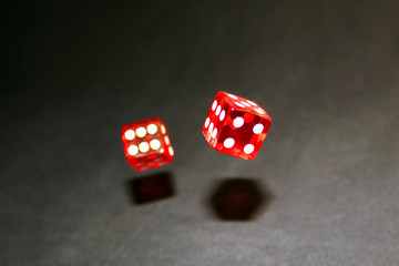 red dice in motion on a black background