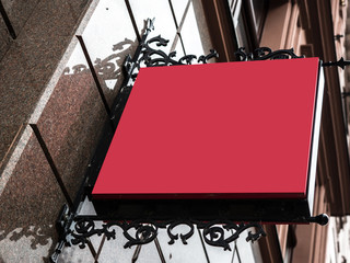 Squared, signboard side view of empty red mock up in a red frame signage with old city wall background display exterior.