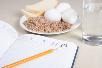 Notebook with buckwheat,bread,eggs and water