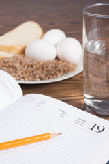 Notebook with buckwheat,bread,eggs and water