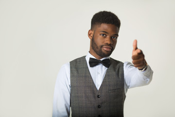 stylish african man in a waistcoat on a white background with a hand gesture