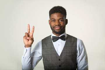 stylish african man in a waistcoat on a white background with a hand gesture