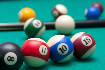 Lots of billiard balls and a cue closeup, macro shot of a professional competitive billiard table