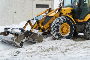 Tractor shoveling snow on the street.