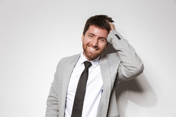 Laughing young businessman in formal clothes isolated over white wall background.