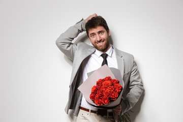 Businessman in formal clothes isolated over white wall background holding flowers.