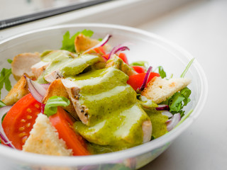 Healthy simple Chicken salad with tomatoes, arugula, green salad dressing and bread croutons in the a glass bowl, Vinaigrette For Green Salad Recipe.