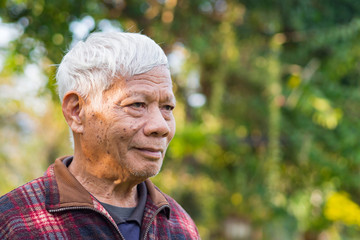 Portrait of elderly man standing in his garden.