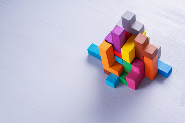 Abstract construction from wooden blocks. Colorful wooden building blocks.