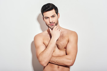 Perfect man. Attractive man looking pensively at the camera isolated over white background