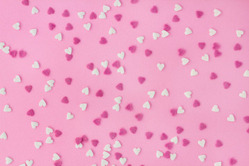 Candy sweets sugar sprinkle decoration in shape of heart on a pink background for wallpaper, card, invitation or poster
