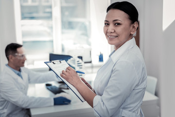 Laboratory assistant making important notes in the laboratory