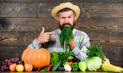 Man with beard proud of his harvest vegetables wooden background. Farmer with organic vegetables. Just from garden. Grocery shop concept. Buy fresh homegrown vegetables. Excellent quality vegetables