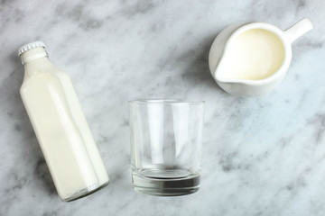 Bottle of milk, glass cup and milk jug