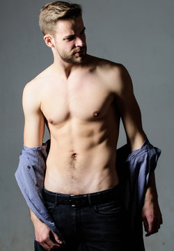 Guy sexy muscular body take off clothes grey background. Full desire. Seductive macho feeling sexy. Bohemian sexy body. Object of desire concept. Man handsome sexy hipster undressing. Feeling flirty