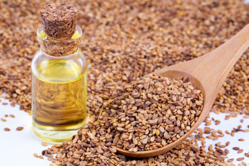 Bottle of sesame oil and sesame seeds isolated
