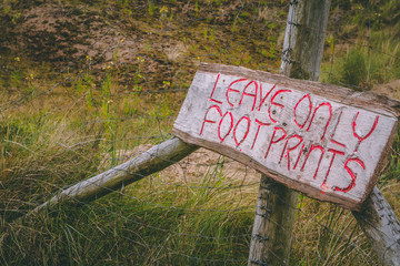 Leave only footprints wooden sign at beach