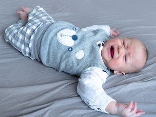 Petulant, peevish, Annoyed, Crying, Angry baby with teddy bear Cute 4 months old mixed half race Asian Caucasian boy in the bed, healthy child baby boy. Half Thai half Polish.