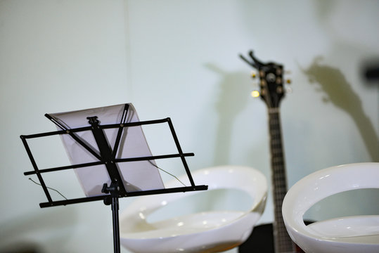 Royalty high quality free stock photo of music stand with microphone and guitar in blurred background 