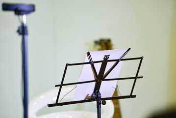 Fototapeta na wymiar Royalty high quality free stock photo of music stand with microphone and guitar in blurred background 