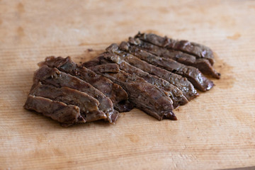 Piece of beef steak on a wooden board in a closeup view