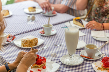 Smoothie in the middle of a table where coffee and cakes have been served