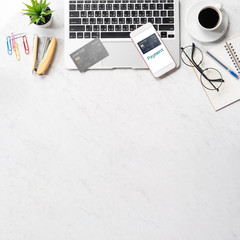 Stylized clean marble home working desk with smartphone, laptop, glasses and coffee, workspace design, mock up, top view, flat lay, copy space, closeup