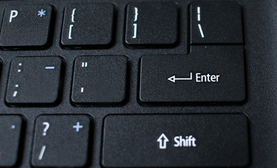 Enter button on laptop keyboard. Close up of Enter key of Laptop computer.  Enter keyboard key button on a computer with light effect. 
