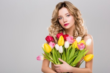 Obraz na płótnie Canvas young attractive spring woman holding bouquet of colorful tulips isolated on grey