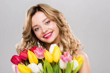 young attractive spring woman holding colorful tulips isolated on grey