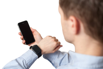 Man using smart watch and smart phone (focus on watch) on white background. App template