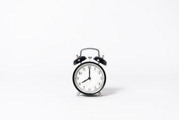 Black alarm clock on gray background. minimal object creative idea.