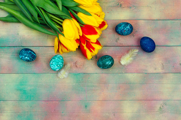 Easter eggs and tulips on wooden planks