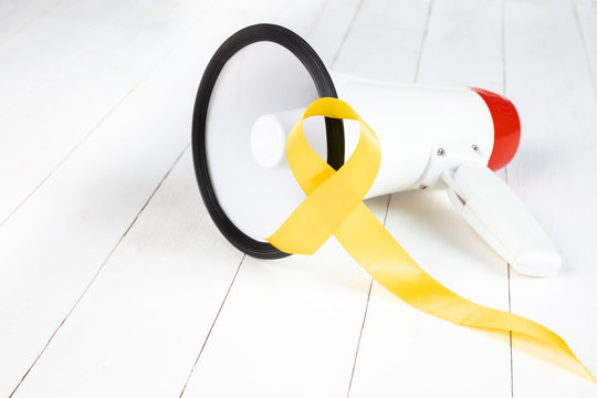 Yellow ribbon symbolic color for Sarcoma Bone cancer awareness and suicide prevention on aged wood with megaphone. The cancer, health, help, care, support, hope, illness, healthcare concept