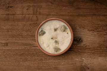 Obraz na płótnie Canvas a bowl of moldy yogurt on wooden table