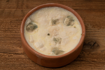 a bowl of moldy yogurt on wooden table