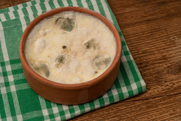 a bowl of moldy yogurt on wooden table
