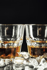 Whiskey and ice on rustic wood background