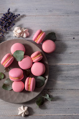Sweet pinky macaroons on the white wooden background. Top view copy space