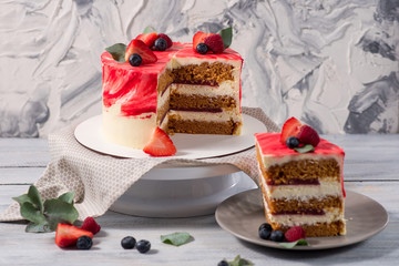 Sweet red cake with strawberries and bluederries on the white wooden background