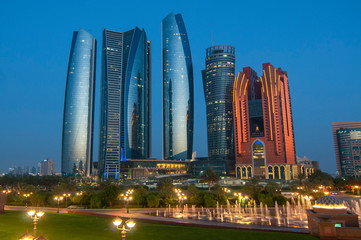Fototapeta na wymiar Skyscrapers of Abu Dhabi at night with Etihad Towers buildings. Abu Dhabi is the capital and the second most populous city of the United Arab Emirates.